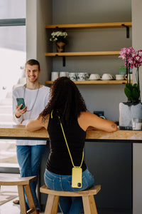 a woman sitting at a counter with a cell phone