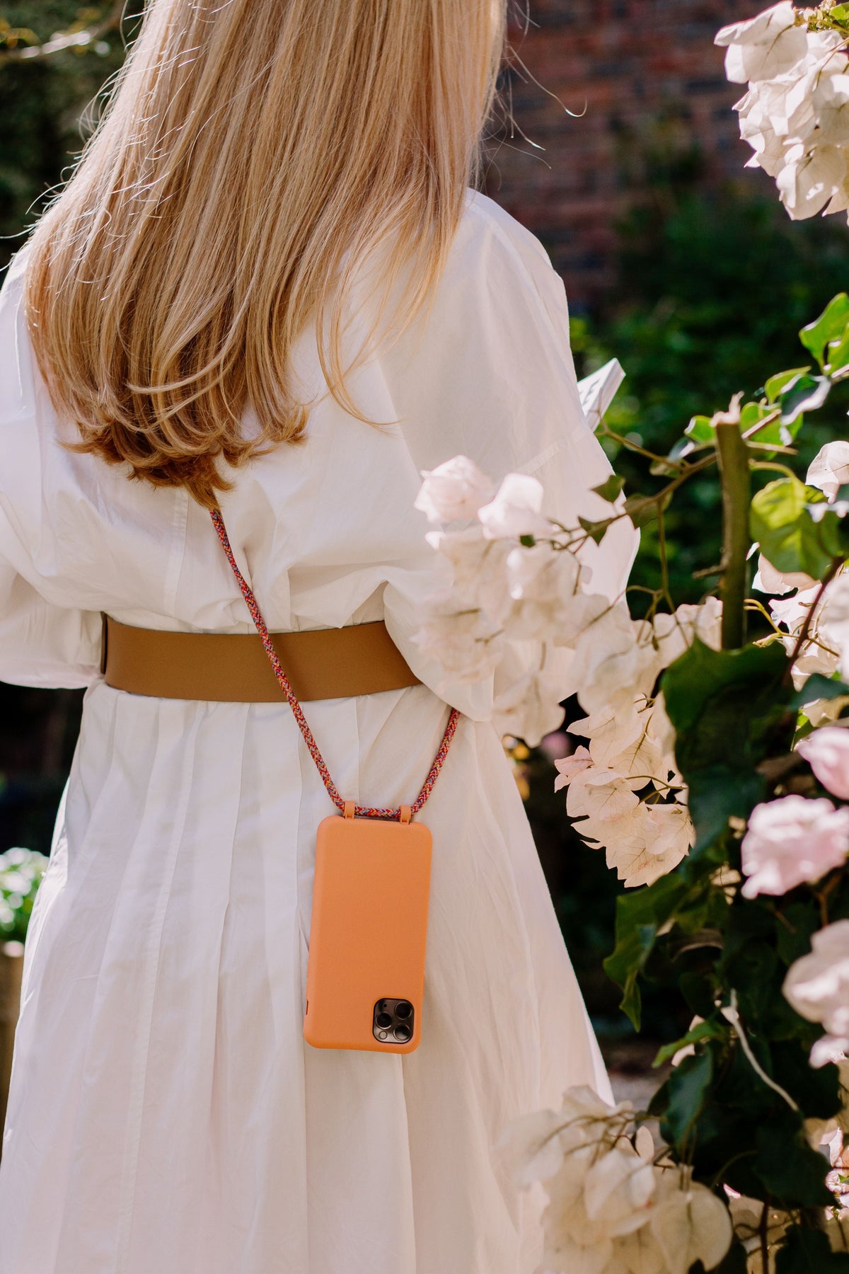 a woman in a white dress holding a cell phone