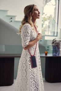 a woman in a white dress holding a cell phone